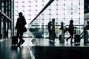 Reisende am Bahnhof im Gegenlicht - Die Kunst des Wartens – was Bahnhöfe über Städte verraten