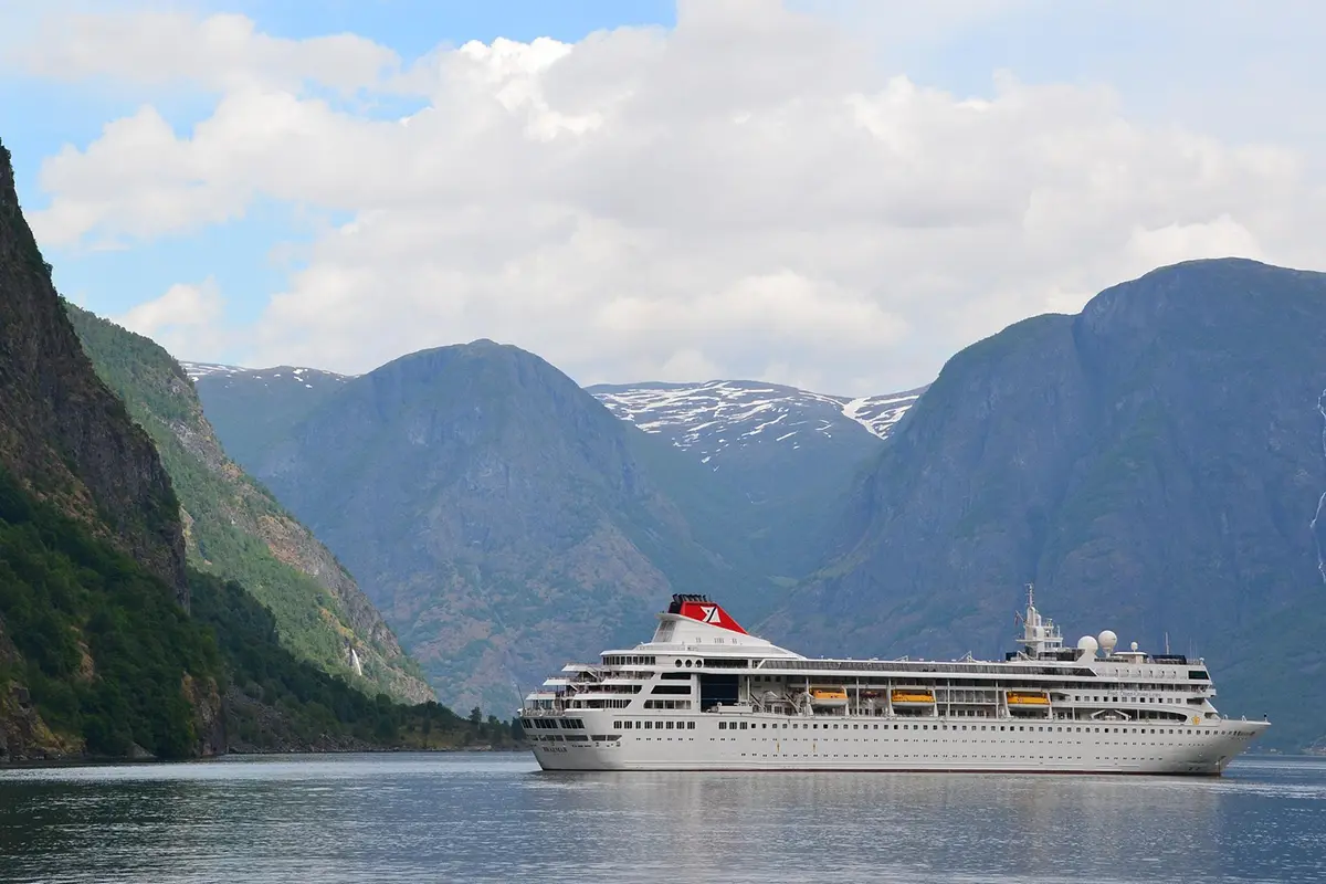 Kreuzfahrt: Schiff im norwegischerm Fjord mit Bergen im Hintergrund