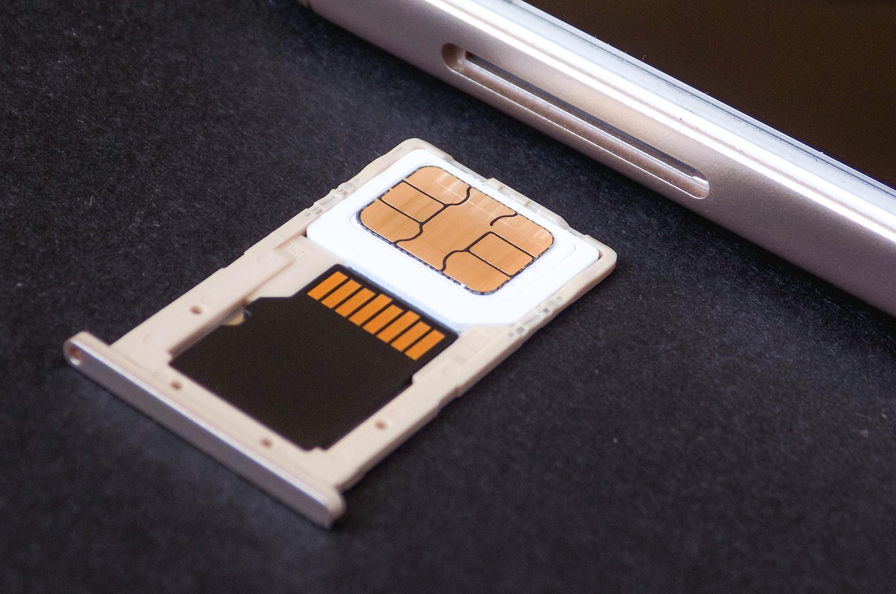SIM-Karte und Speicherkarte im Kartenschlitten eines Smartphones – Symbol für mobile Datennutzung auf Reisen