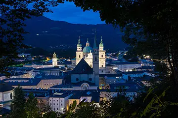 Die Salzburger Altstadt im blauen Abendlicht, der Dom angestrahlt als weißer Kontrast